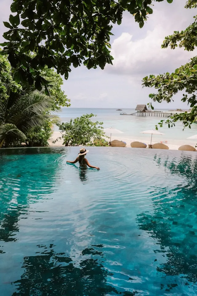 Exclusive Maldives resort experience featuring a private infinity pool facing a pristine turquoise ocean lagoon